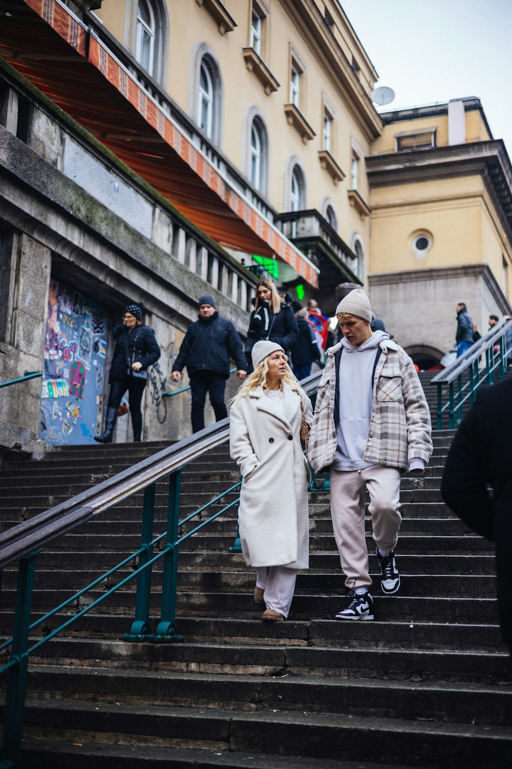 a man and a woman walking down a flight of stairs