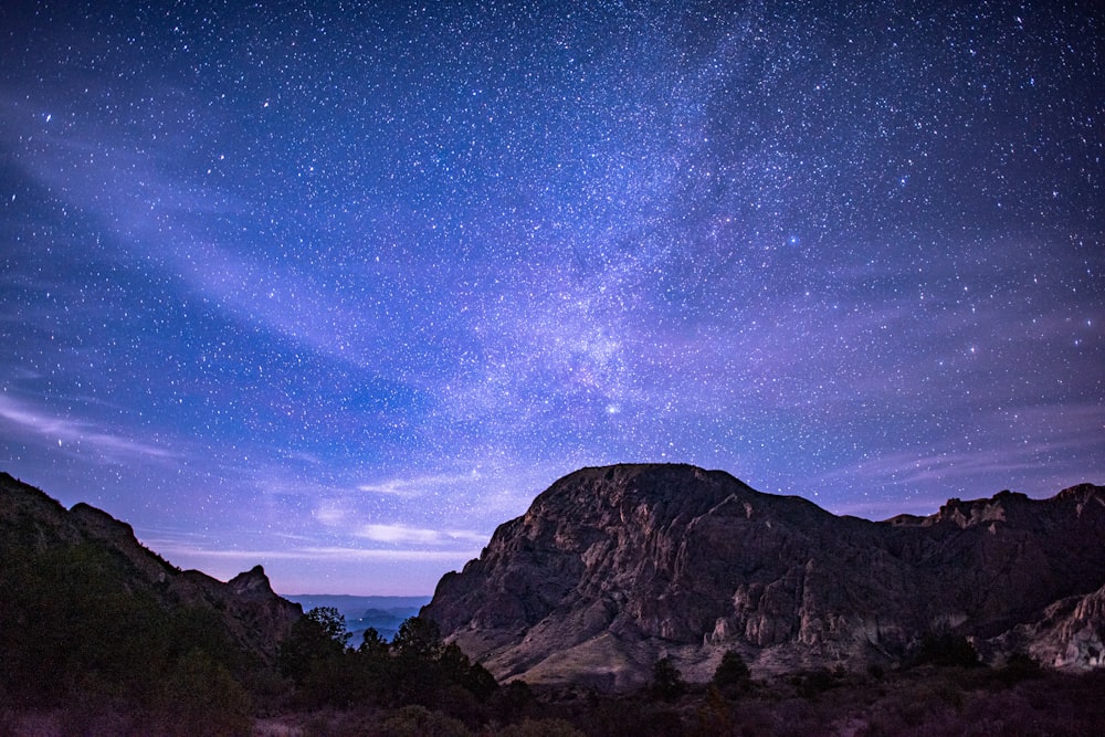 Il cielo notturno con le stelle sopra una catena montuosa