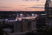Historic Philadelphia skyline at sunset with a sports stadium glowing in the foreground.