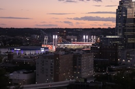 Historic Philadelphia skyline at sunset with a sports stadium glowing in the foreground.