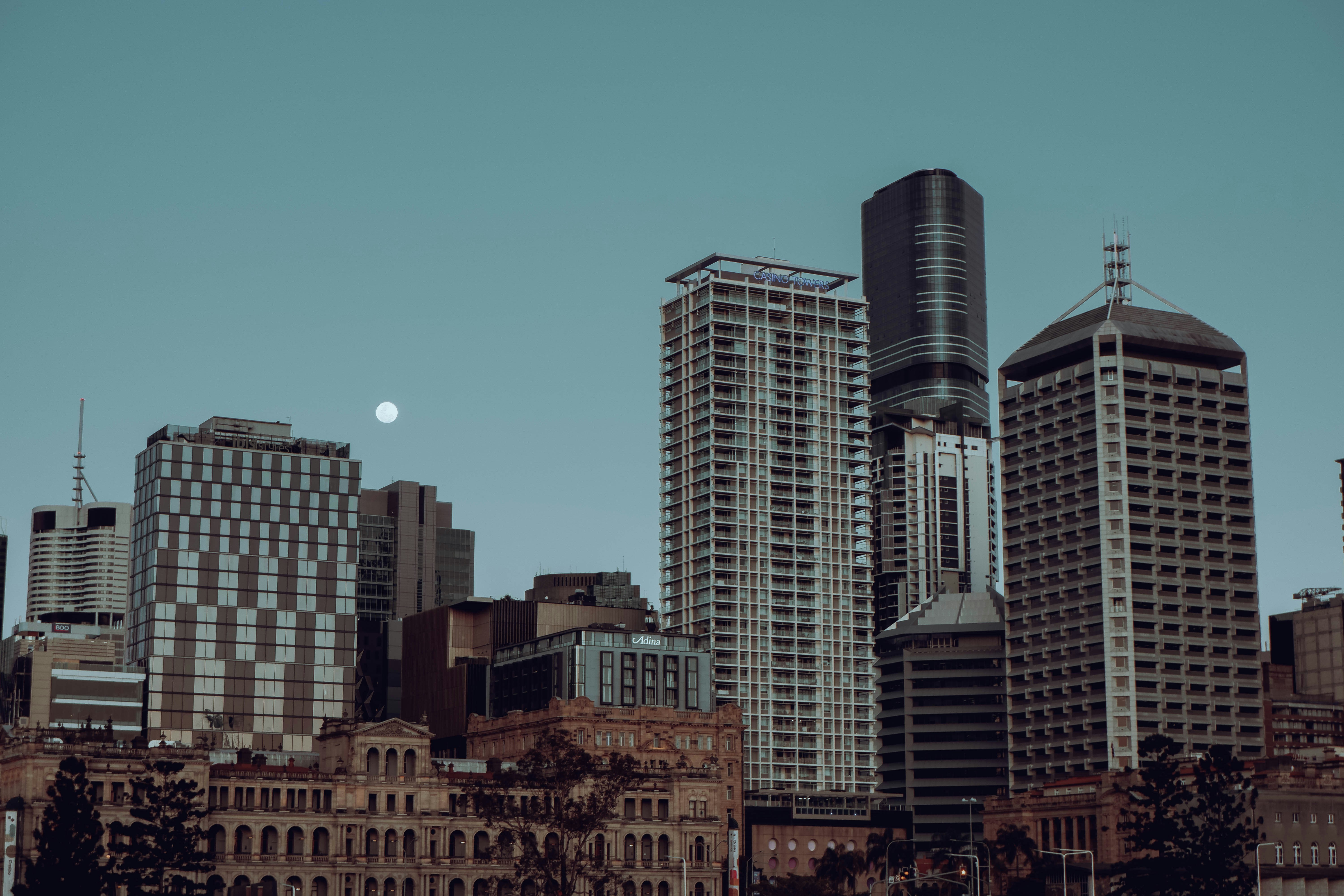 a full moon rises over a city skyline