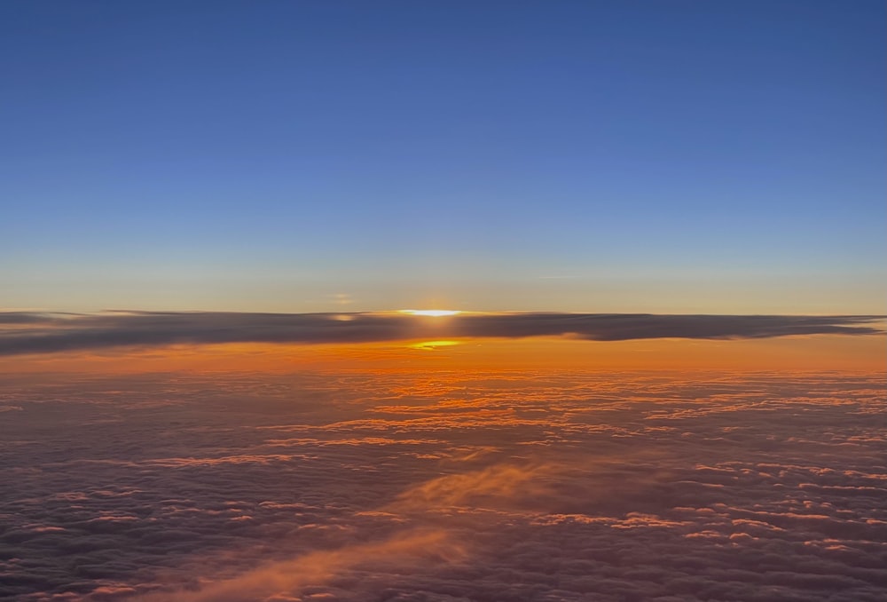 the sun is setting over the clouds in the sky