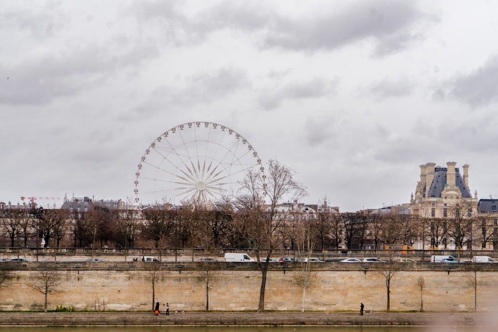 une grande roue assise au bord d’une rivière