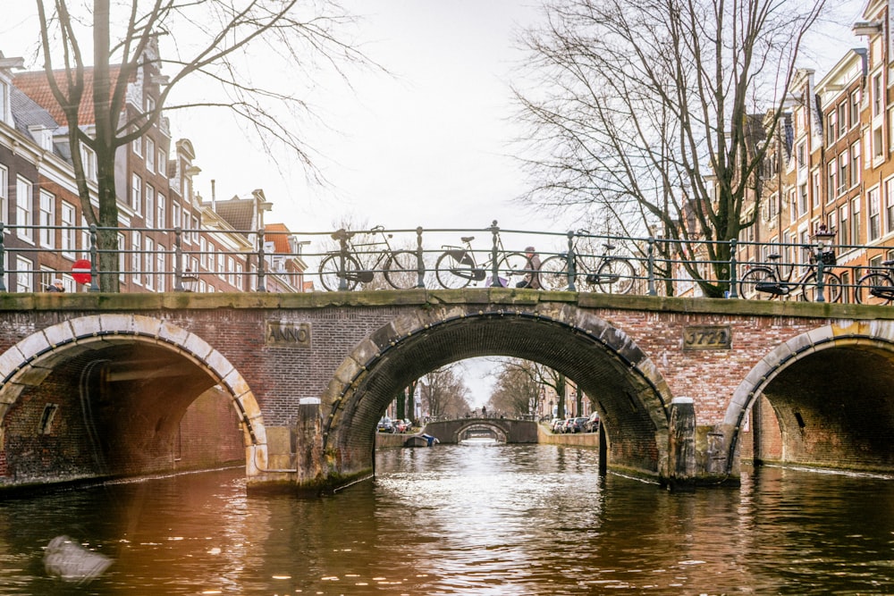 a bridge over a canal with bicycles on it