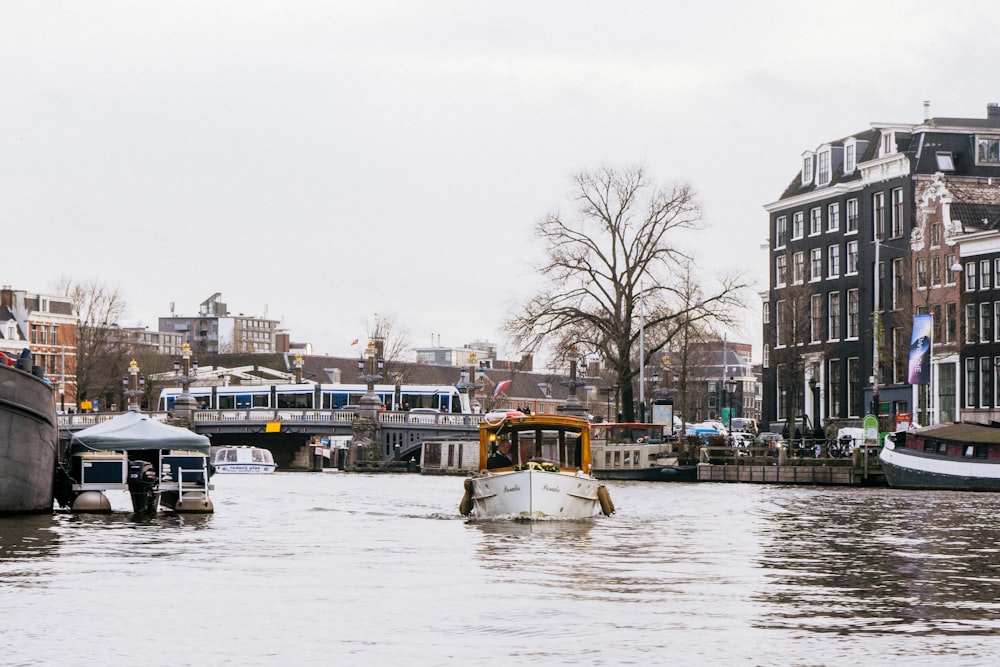 a boat traveling down a river next to tall buildings