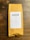 A package of coffee labeled 'DEVOCIÓN', featuring details about its Colombian origin, including variety, region, altitude, and flavor notes. The package is placed on a rustic wooden surface.