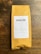 A package of coffee labeled 'DEVOCIÓN', featuring details about its Colombian origin, including variety, region, altitude, and flavor notes. The package is placed on a rustic wooden surface.