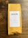 A package of coffee labeled 'DEVOCIÓN', featuring details about its Colombian origin, including variety, region, altitude, and flavor notes. The package is placed on a rustic wooden surface.