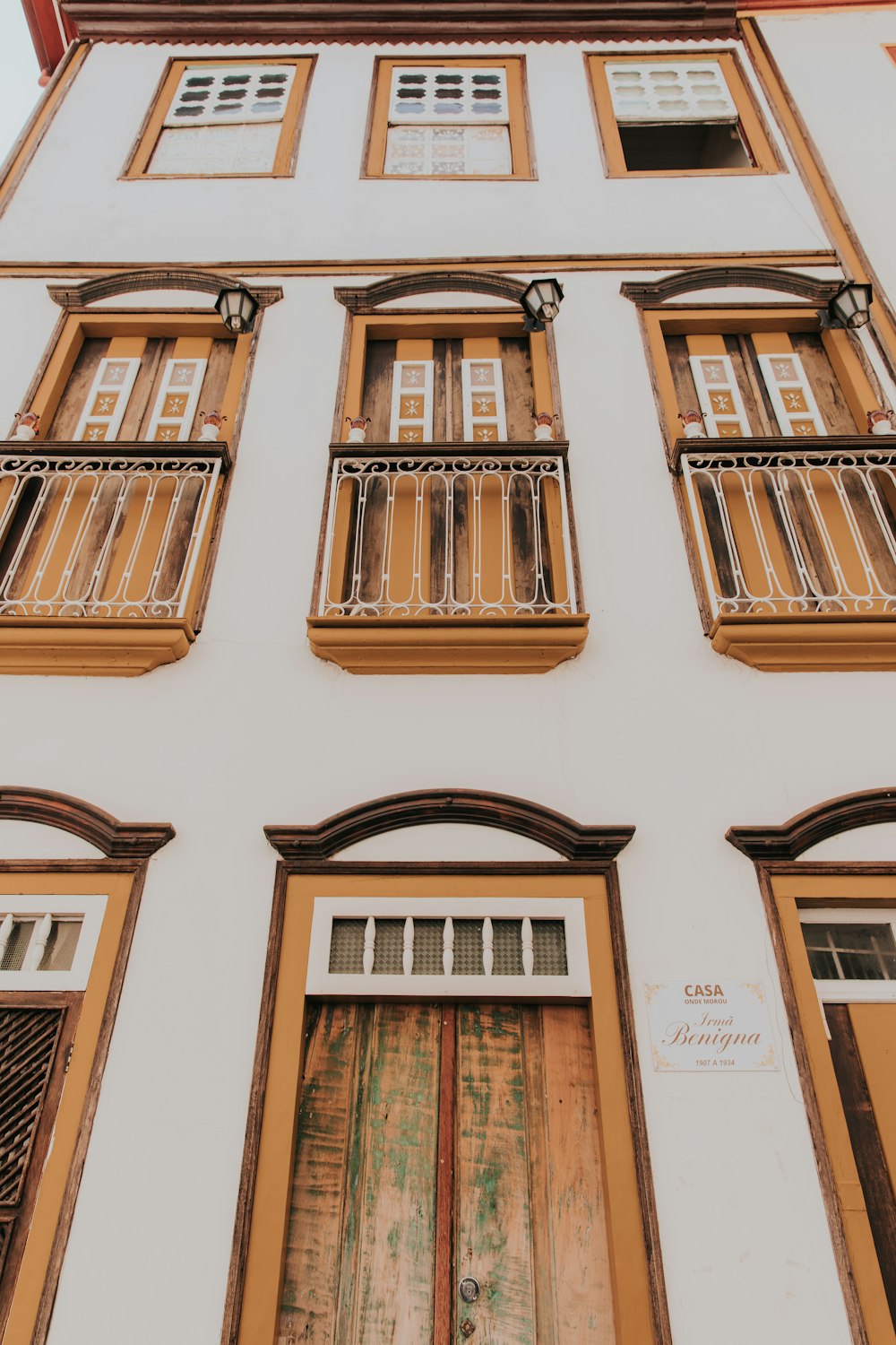 a tall white building with wooden doors and windows