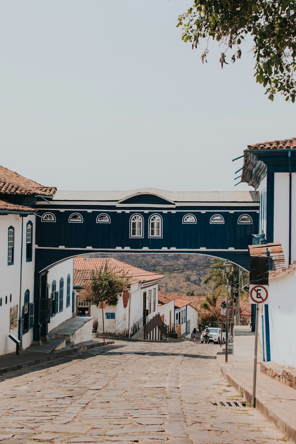 a blue bridge over a cobblestone street