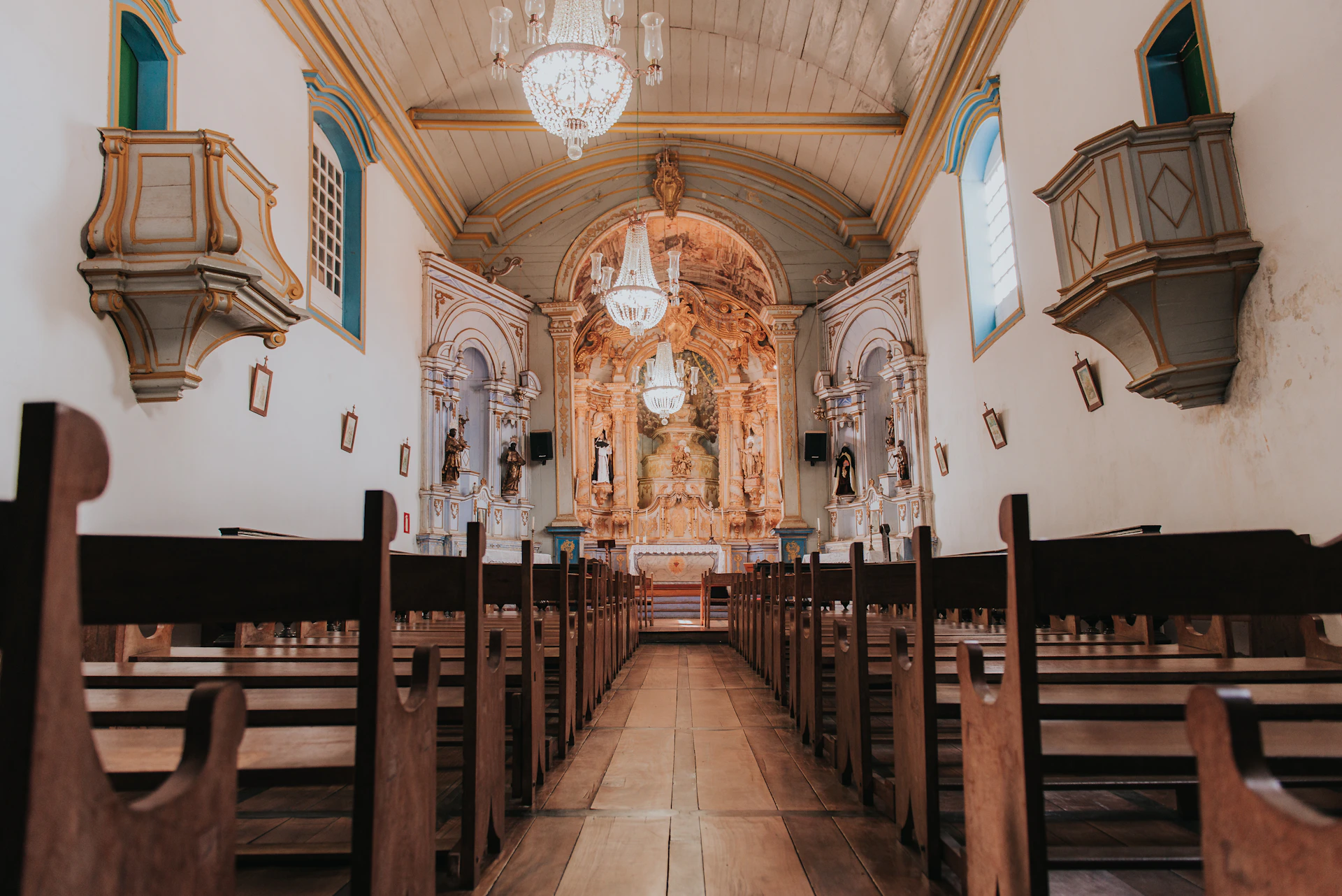 the inside of a church with pews and chandeliers