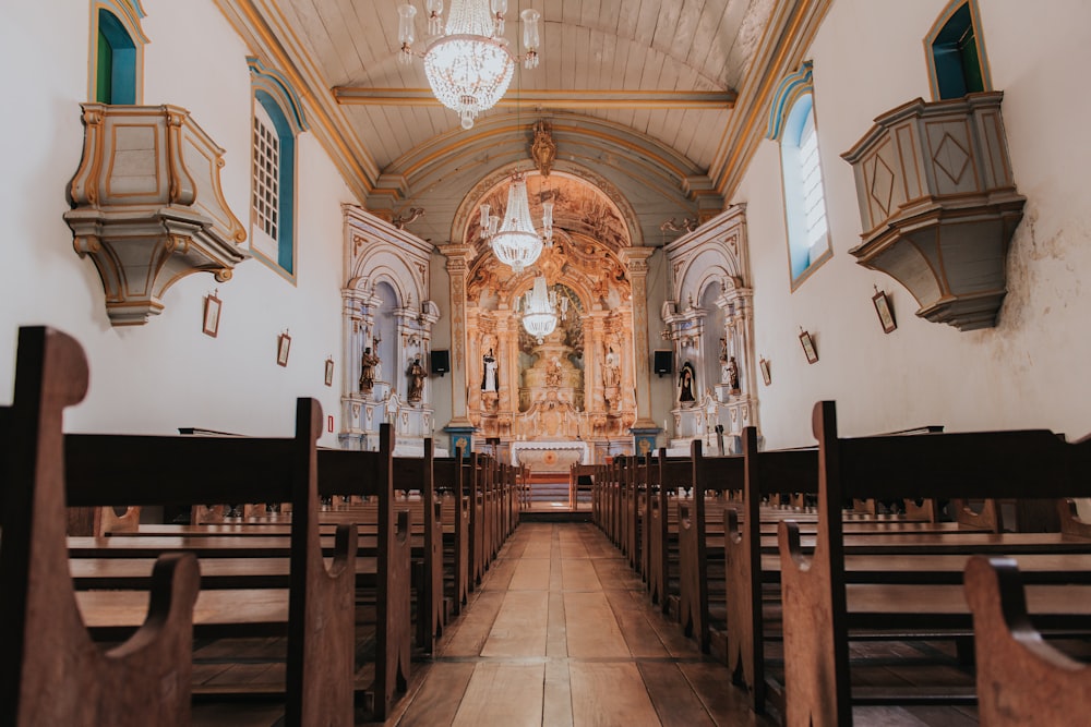 the inside of a church with pews and chandeliers