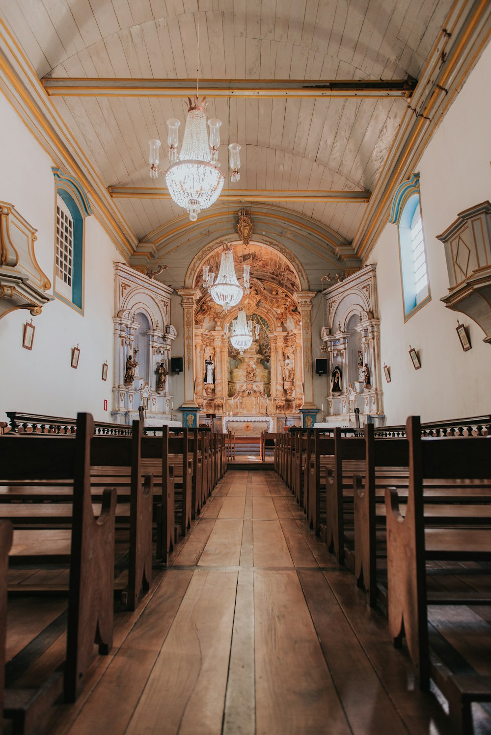 the inside of a church with pews and chandeliers