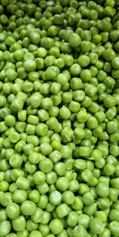 a pile of green peas sitting next to each other