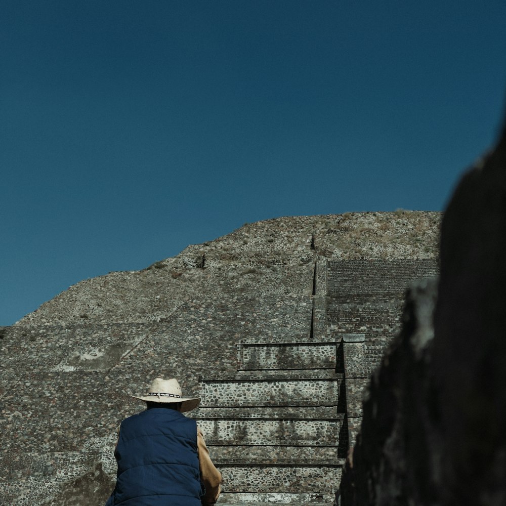 a man in a hat is walking up some stairs