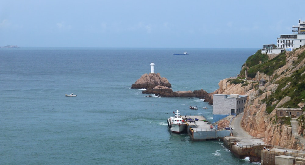 a boat is in the water near a lighthouse