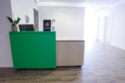 a green cabinet in an office with a plant on top of it