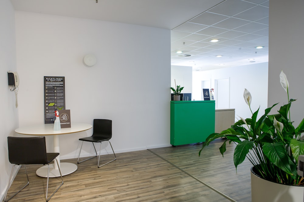 a room with a table, chairs, and a sign on the wall