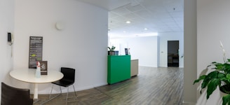 a room with a white table and a green cabinet