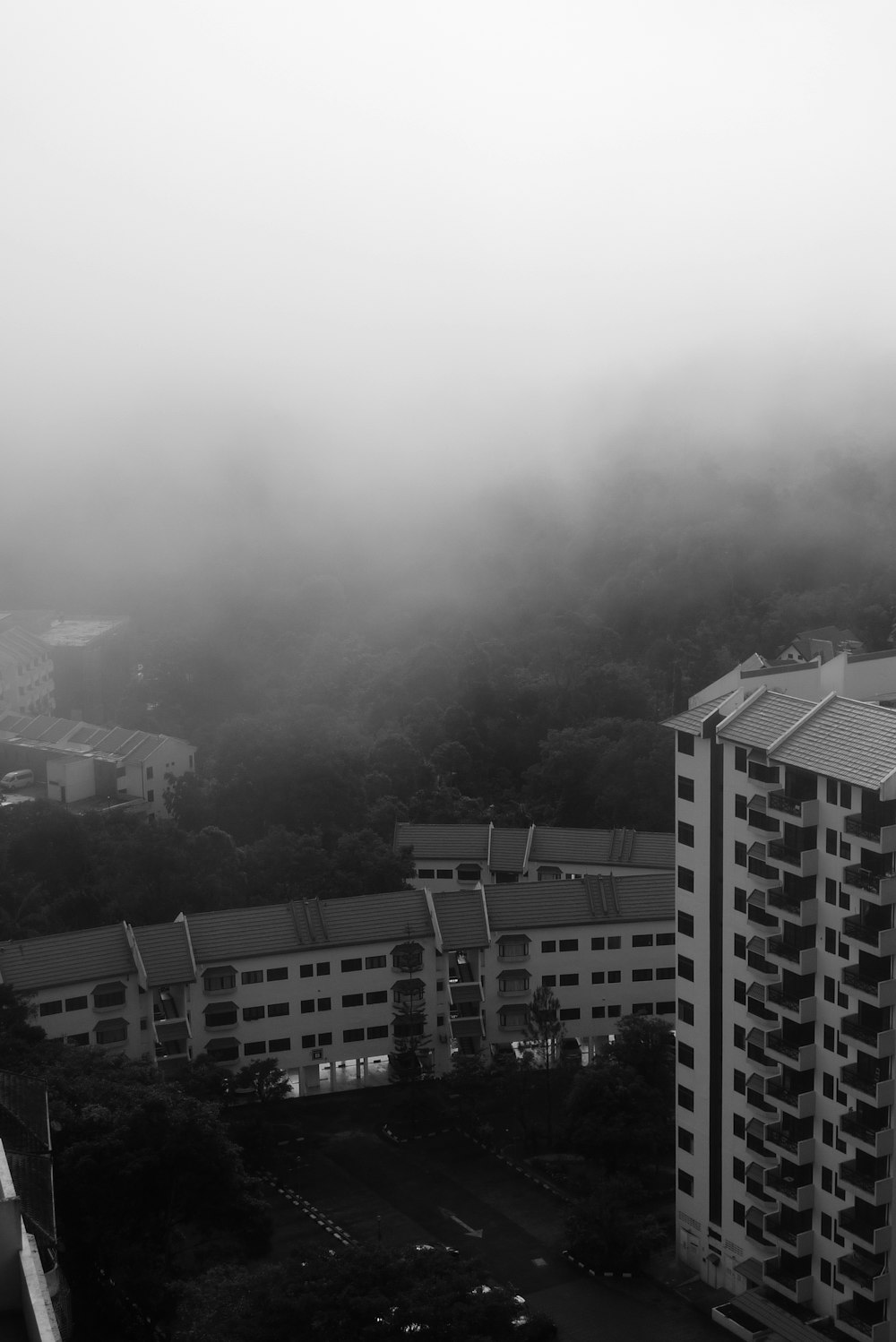 a black and white photo of a foggy city