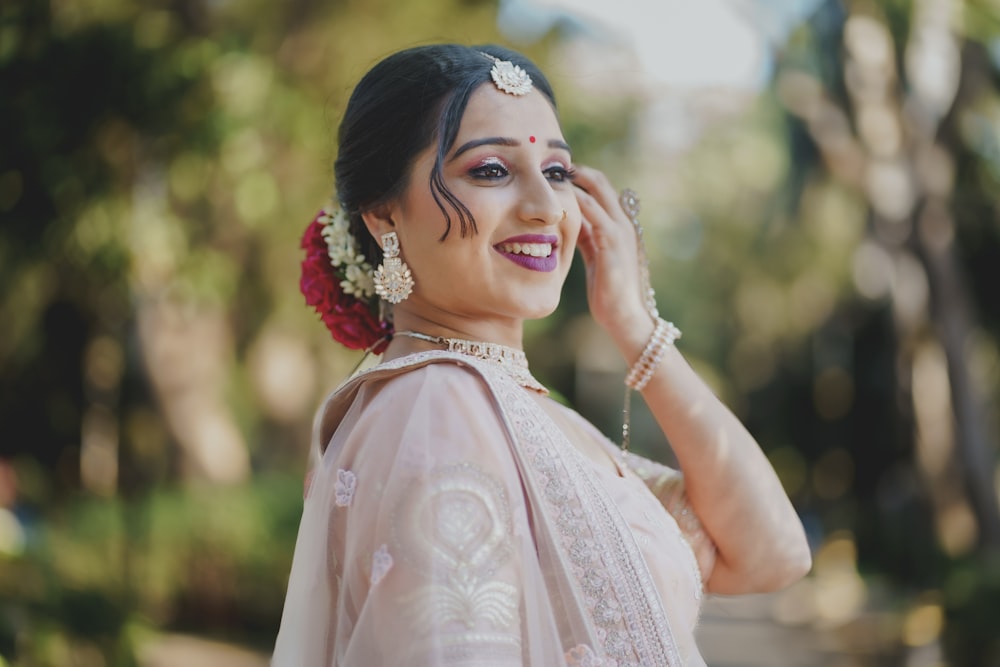 a woman in a white sari is talking on a cell phone