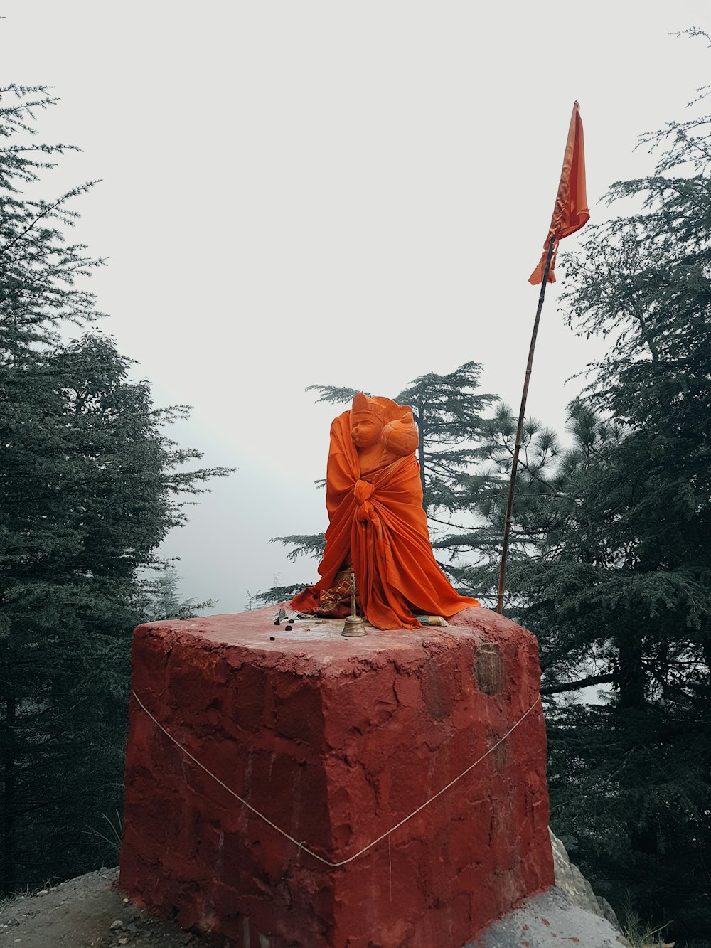 a statue of a person sitting on top of a rock