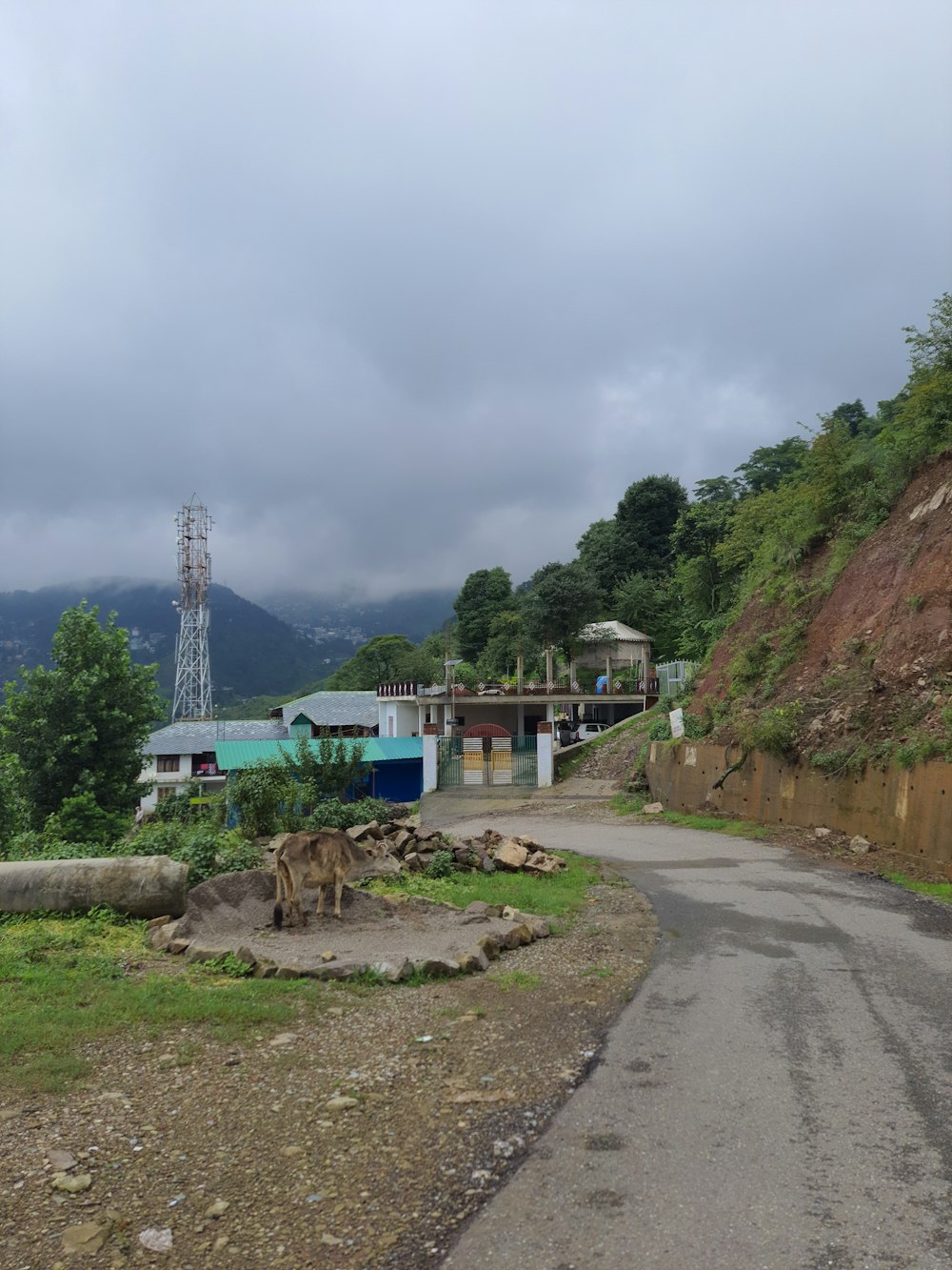 a dirt road with a building on the side of it