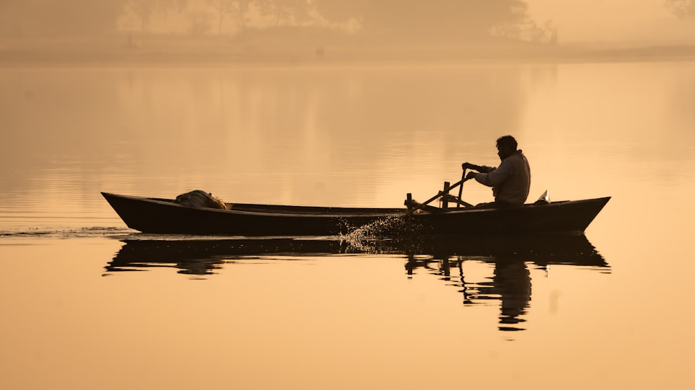 a man sitting in a boat on a lake