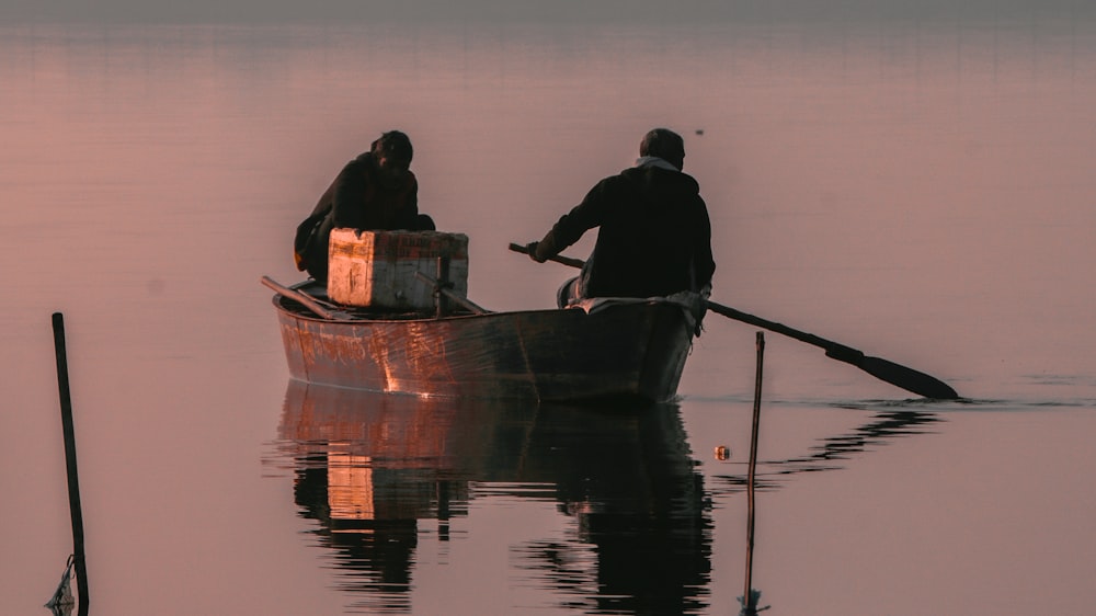 two people in a row boat on a lake