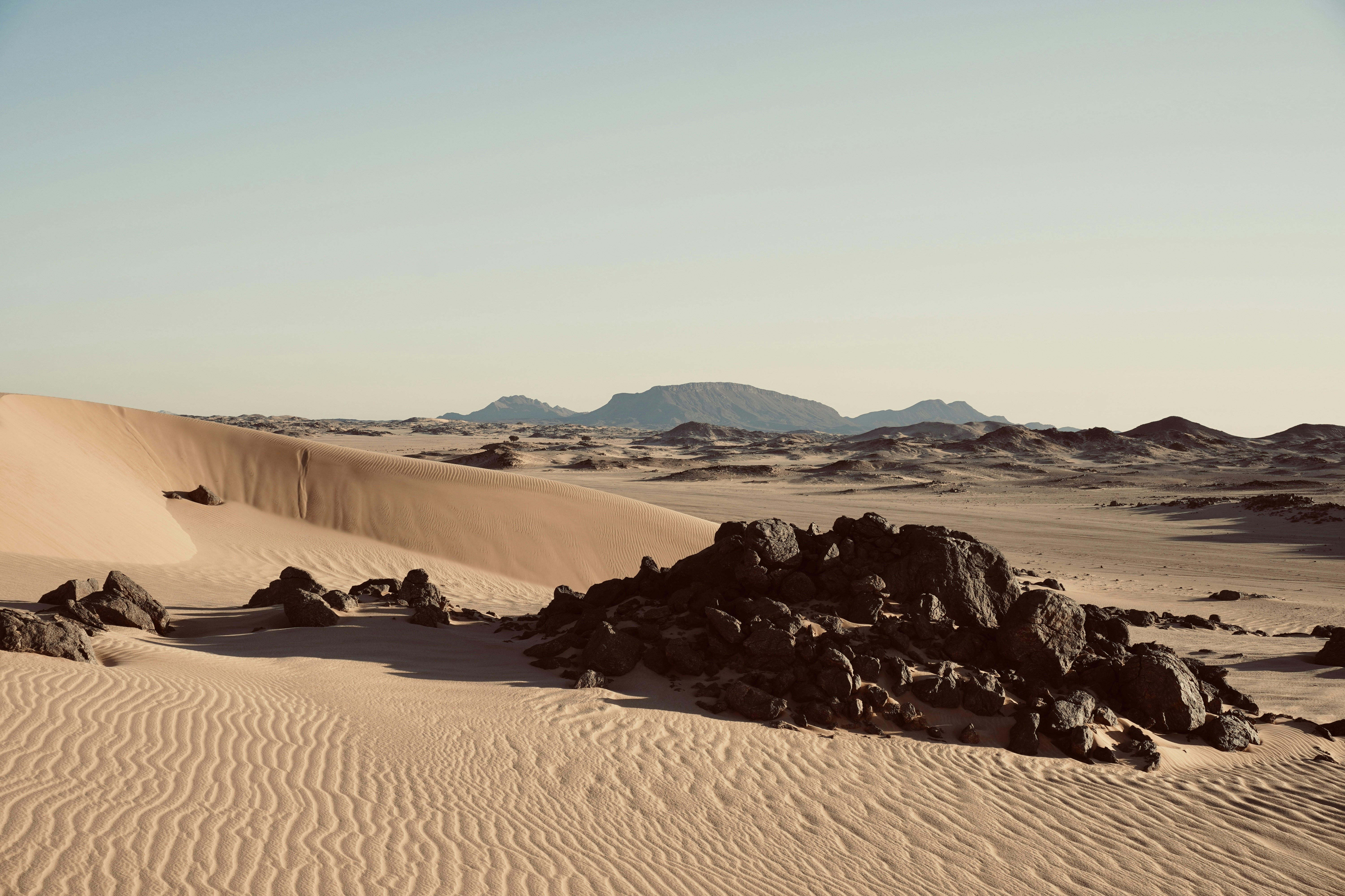 a desert scene with rocks and sand dunes