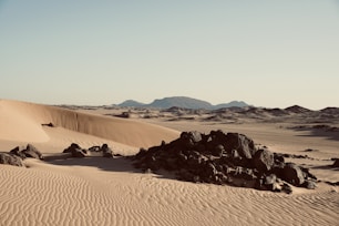 a desert scene with rocks and sand dunes