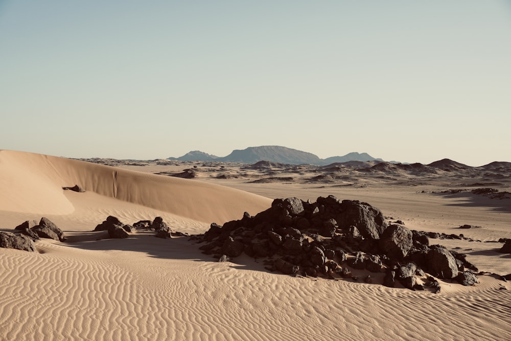 a desert scene with rocks and sand dunes