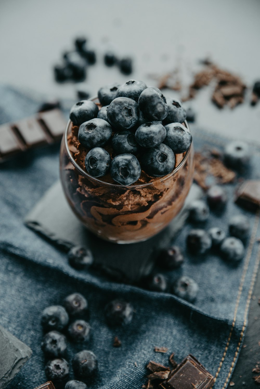 a glass bowl filled with blueberries and chocolate