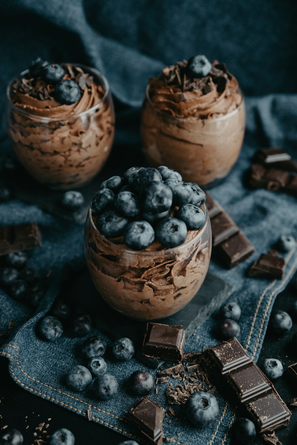 two jars of chocolate pudding with blueberries and chocolate chips