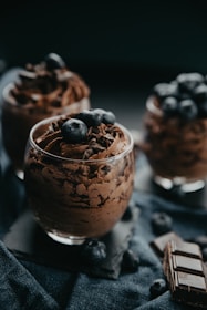 An elegant dessert plate featuring a rich chocolate mousse garnished with fresh berries and mint.