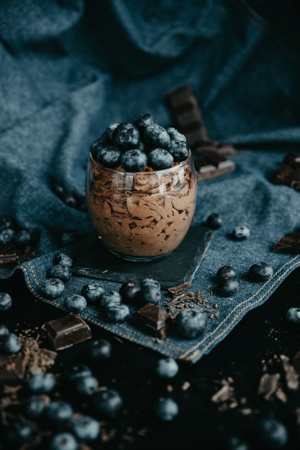 uma tigela de vidro cheia de mirtilos e chocolate