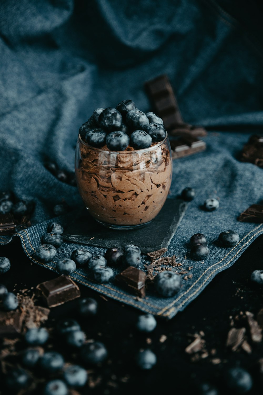 a glass bowl filled with blueberries and chocolate