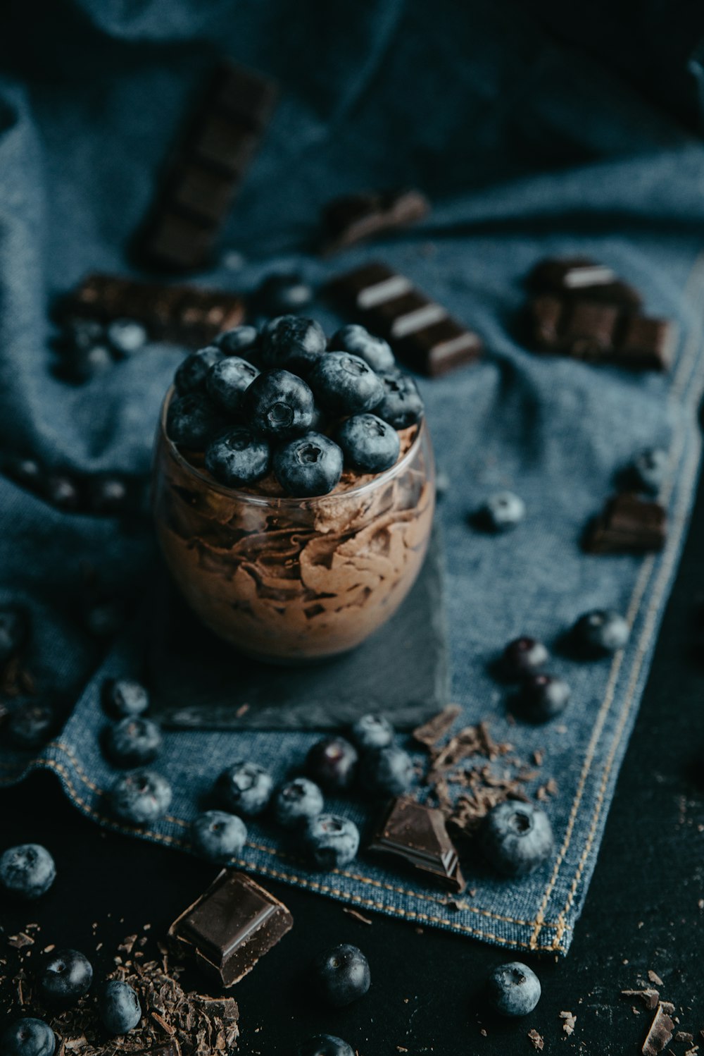 a glass jar filled with chocolate and blueberries