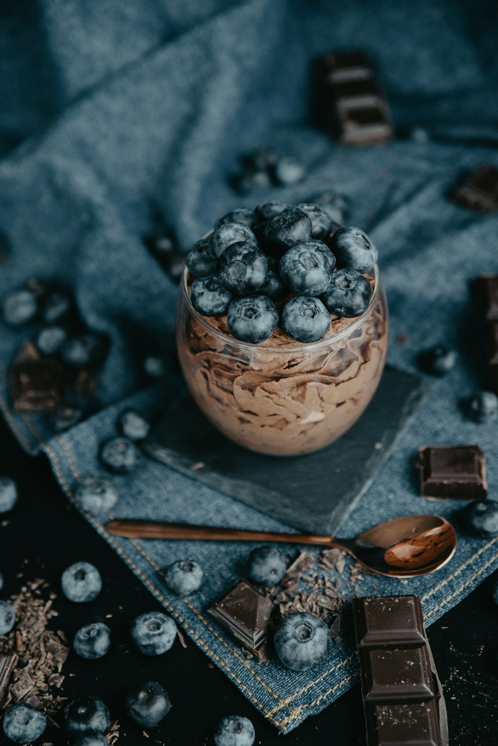 a bowl of blueberries and chocolate on a cloth