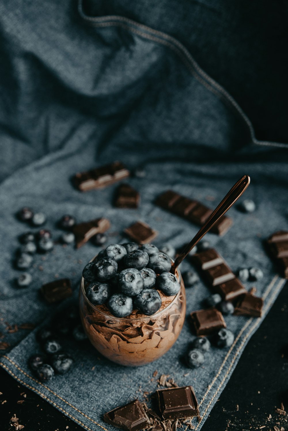 a bowl of blueberries and chocolate on a cloth