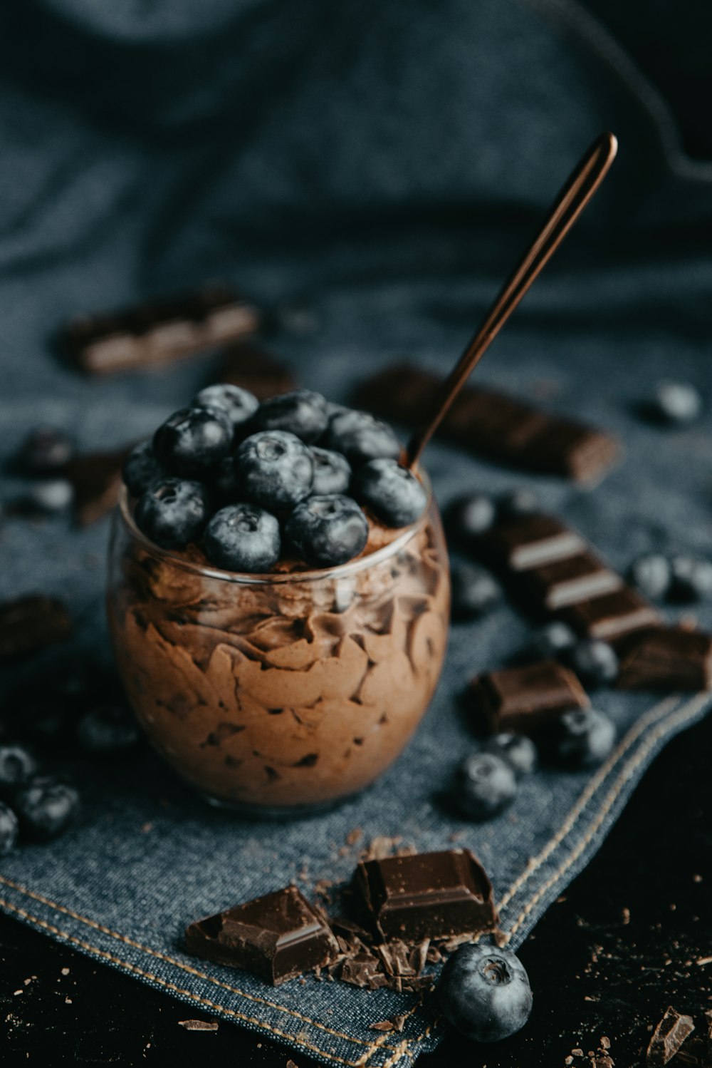 a bowl of blueberries and chocolate on a cloth