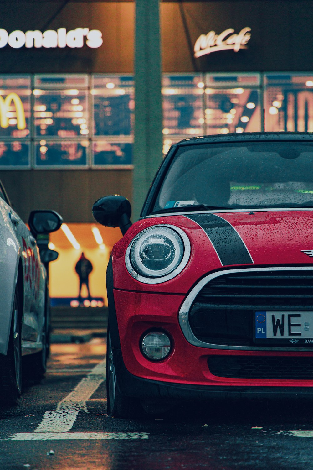 a red car parked in front of a mcdonald's