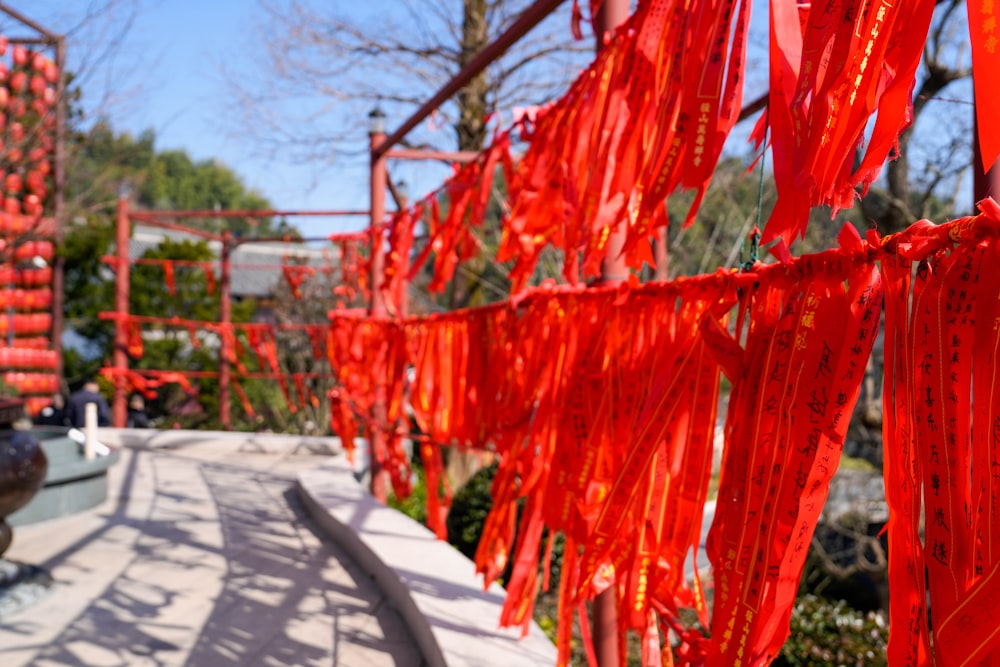 a long line of red ribbons hanging from the side of a building