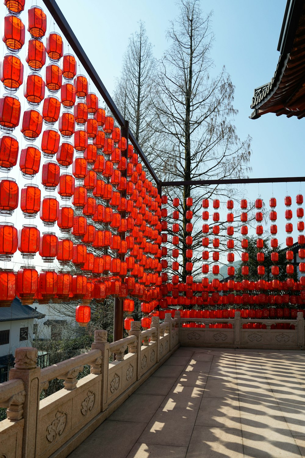 a walkway lined with red lanterns hanging from the ceiling