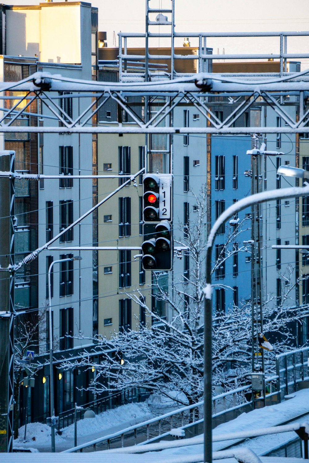 a traffic light in the middle of a snowy city