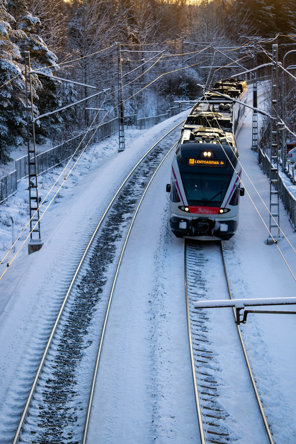 a train traveling down train tracks in the snow