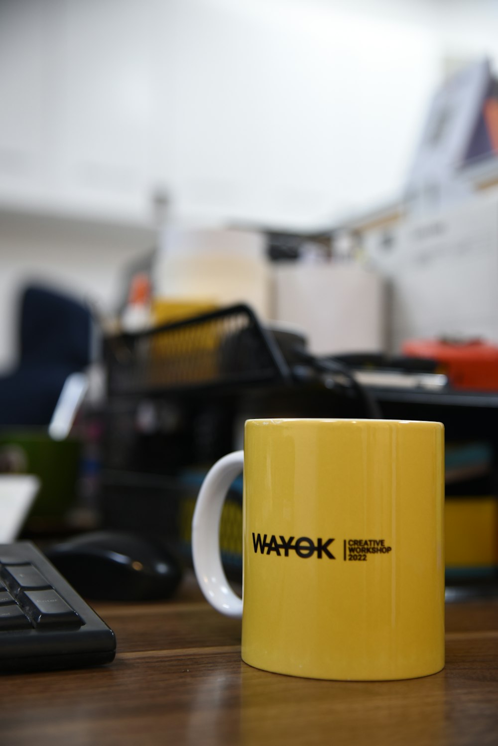 a yellow coffee mug sitting on top of a wooden desk
