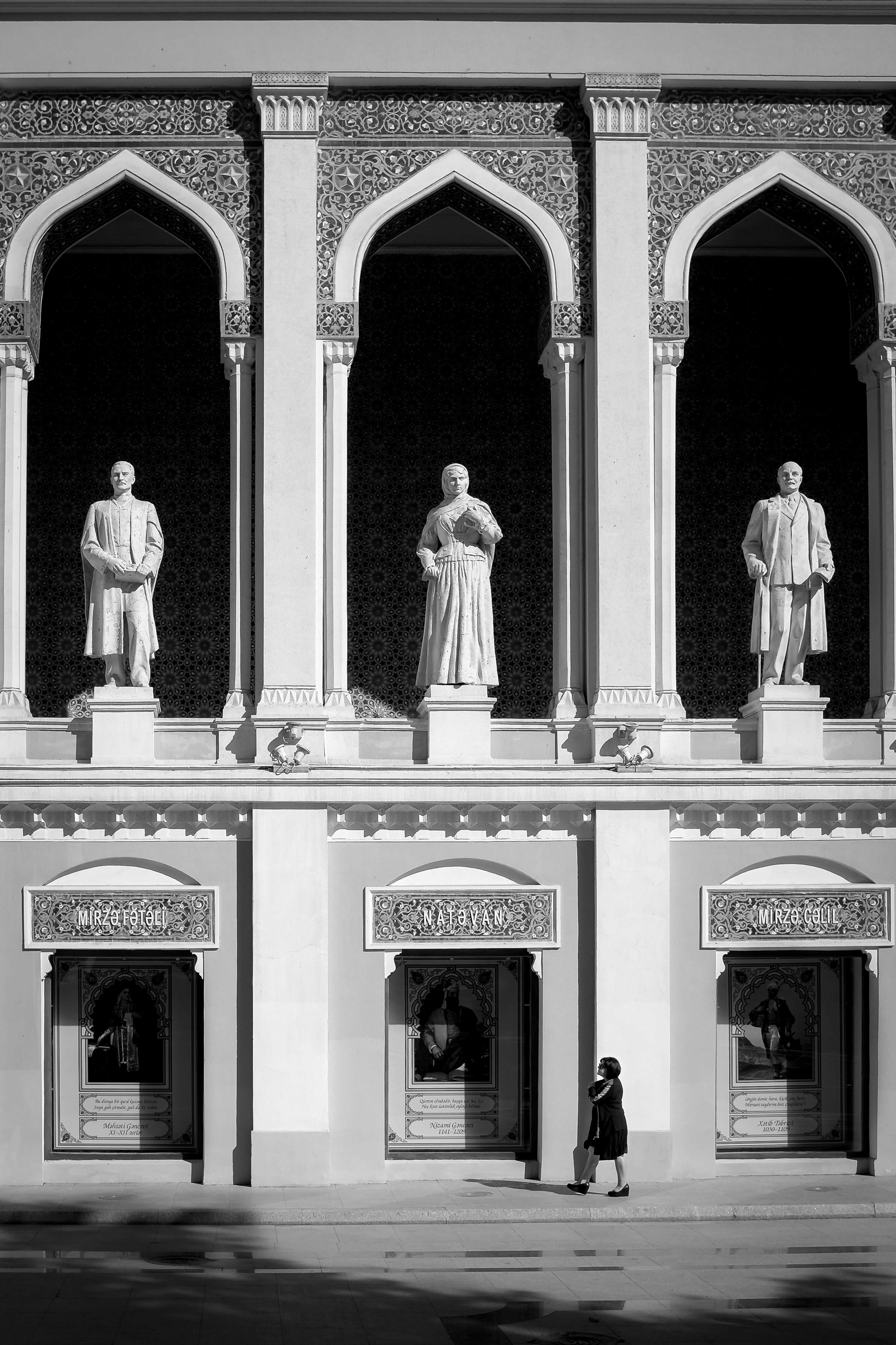 a black and white photo of a building with statues