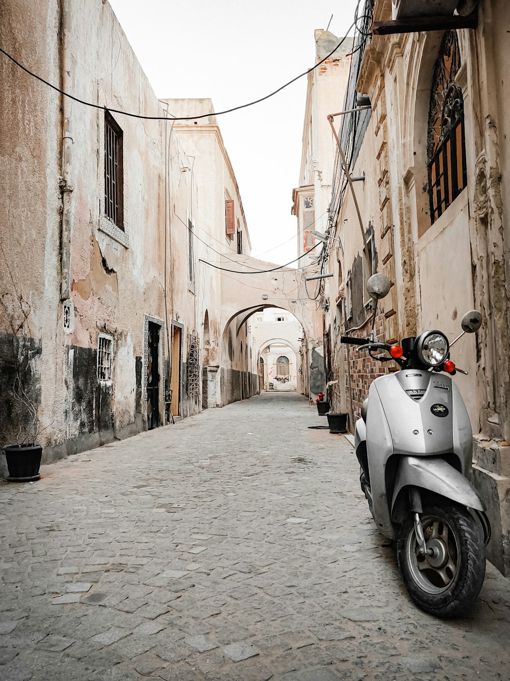 a scooter is parked on a cobblestone street