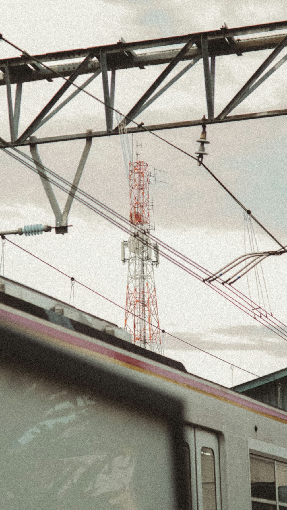 a train traveling past a tall building under a cloudy sky